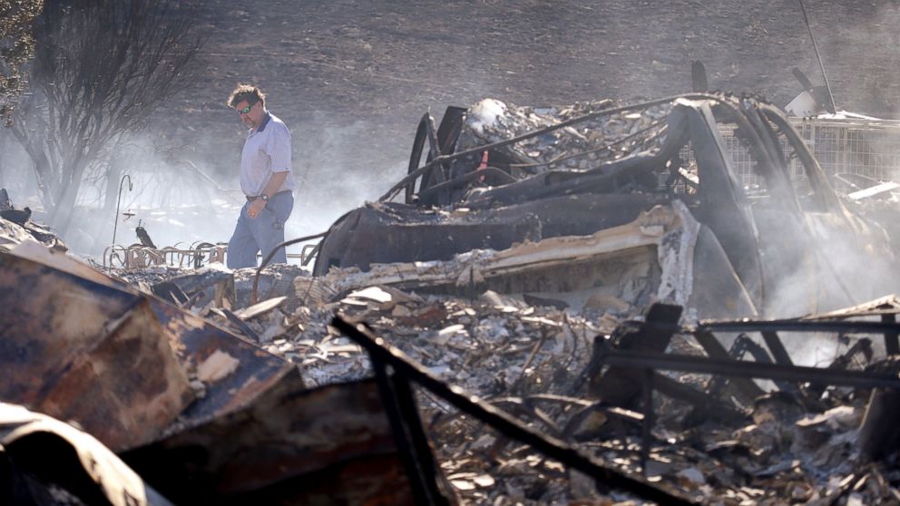 PHOTO: A man walks through the rubble of his still smoldering home, destroyed in a wildfire the night before, June 29, 2015, in Wenatchee, Wash.