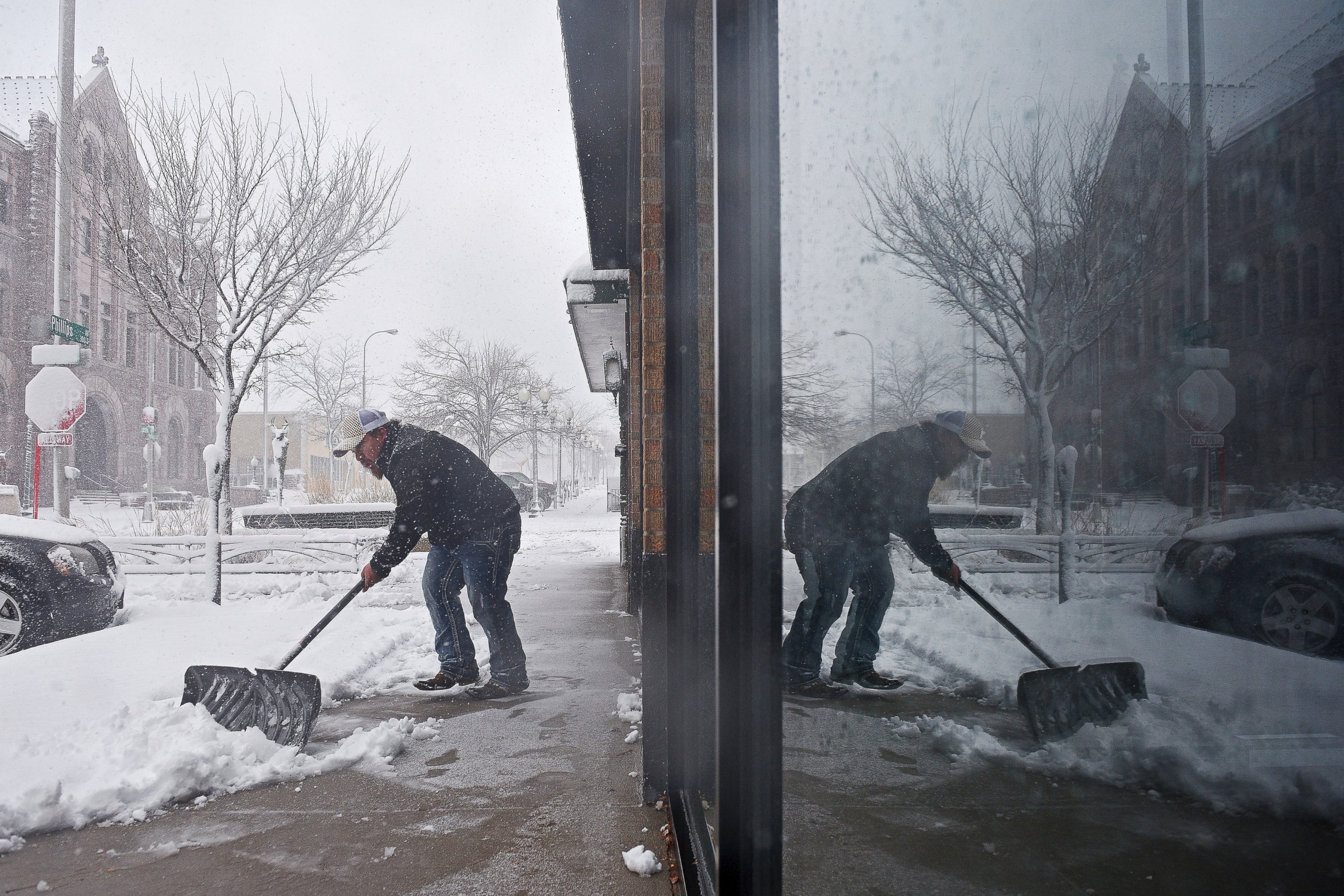 PHOTO: Philip Peter shovels snow in front of the restaurant during a snow storm, Nov. 18, 2016, in Sioux Falls, South Dakota. 