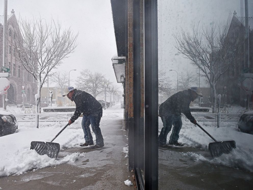 PHOTO: Philip Peter shovels snow in front of the restaurant during a snow storm, Nov. 18, 2016, in Sioux Falls, South Dakota.