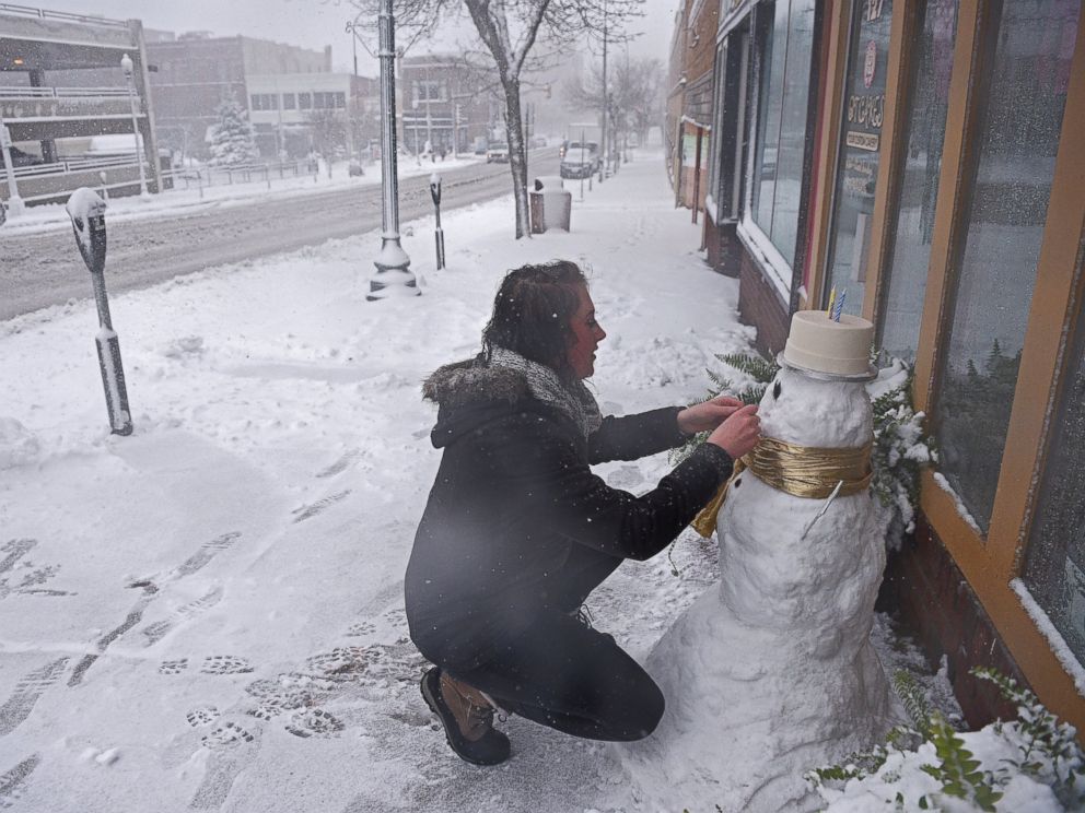 PHOTO: Cassie Maurer, with QT Cakes, puts the finishing touches on a snow man in front of the shop during a snow storm, Nov. 18, 2016, in Sioux Falls, South Dakota.
