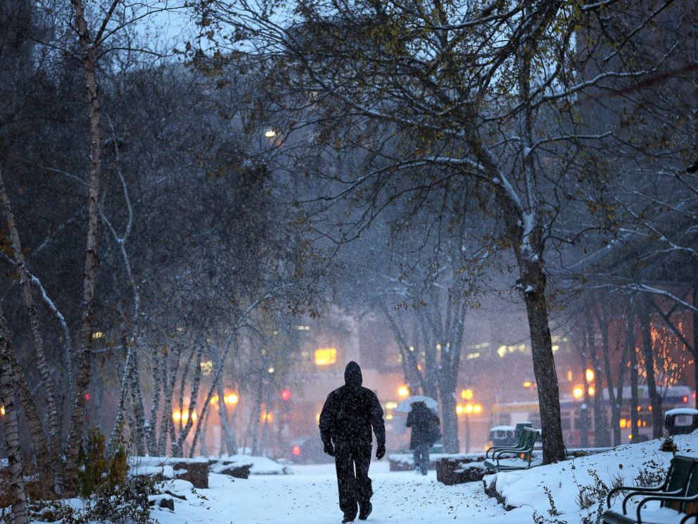 PHOTO: A man walks through Mears Park in downtown St. Paul, Minn., during the first snowstorm of the season, Nov. 10, 2014.