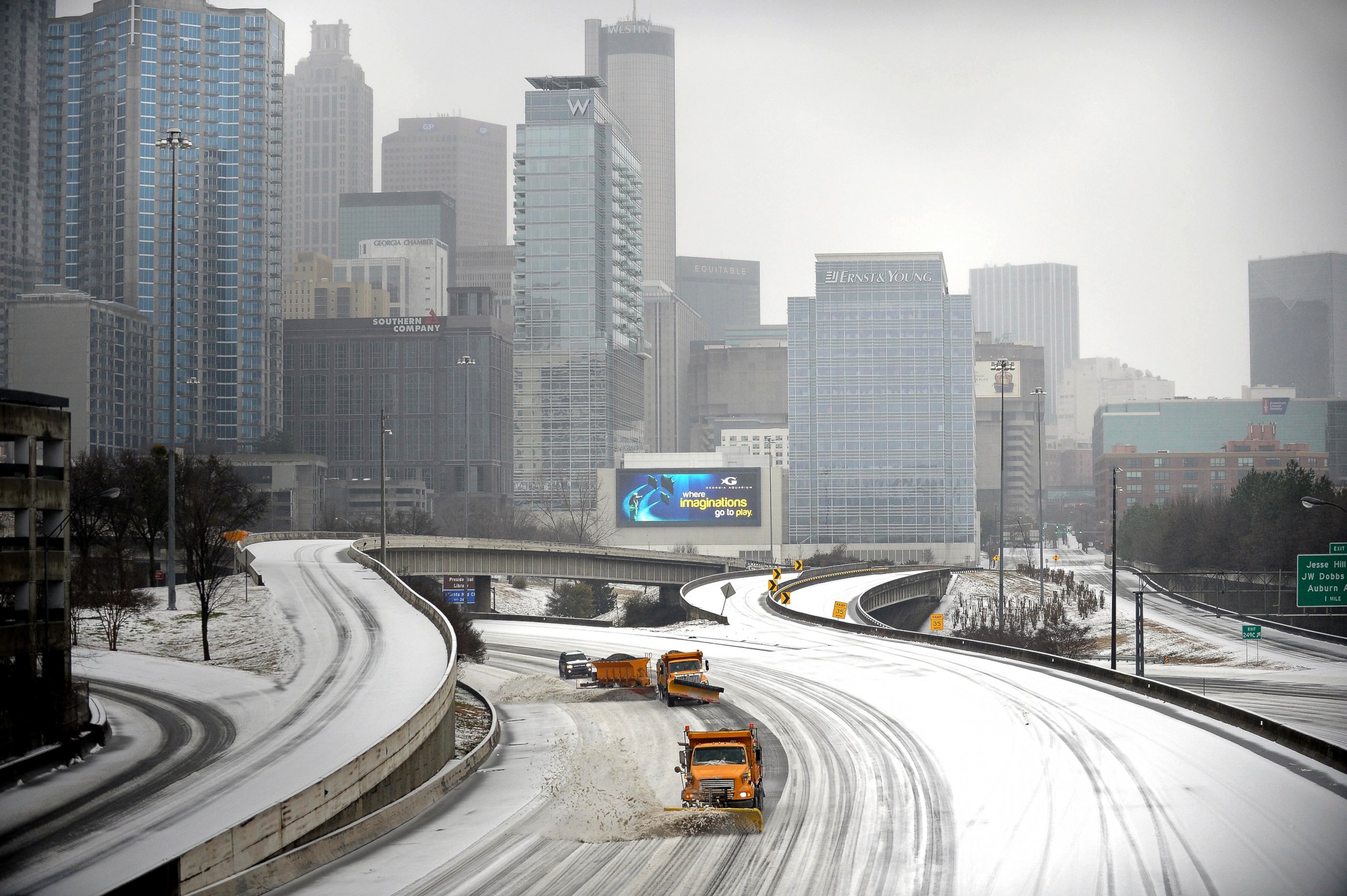 PHOTO: Snow plows clear Interstate 75/85 on the downtown connector while transportation and business grinds to a halt during a winter storm, Feb. 12, 2014, in Atlanta.