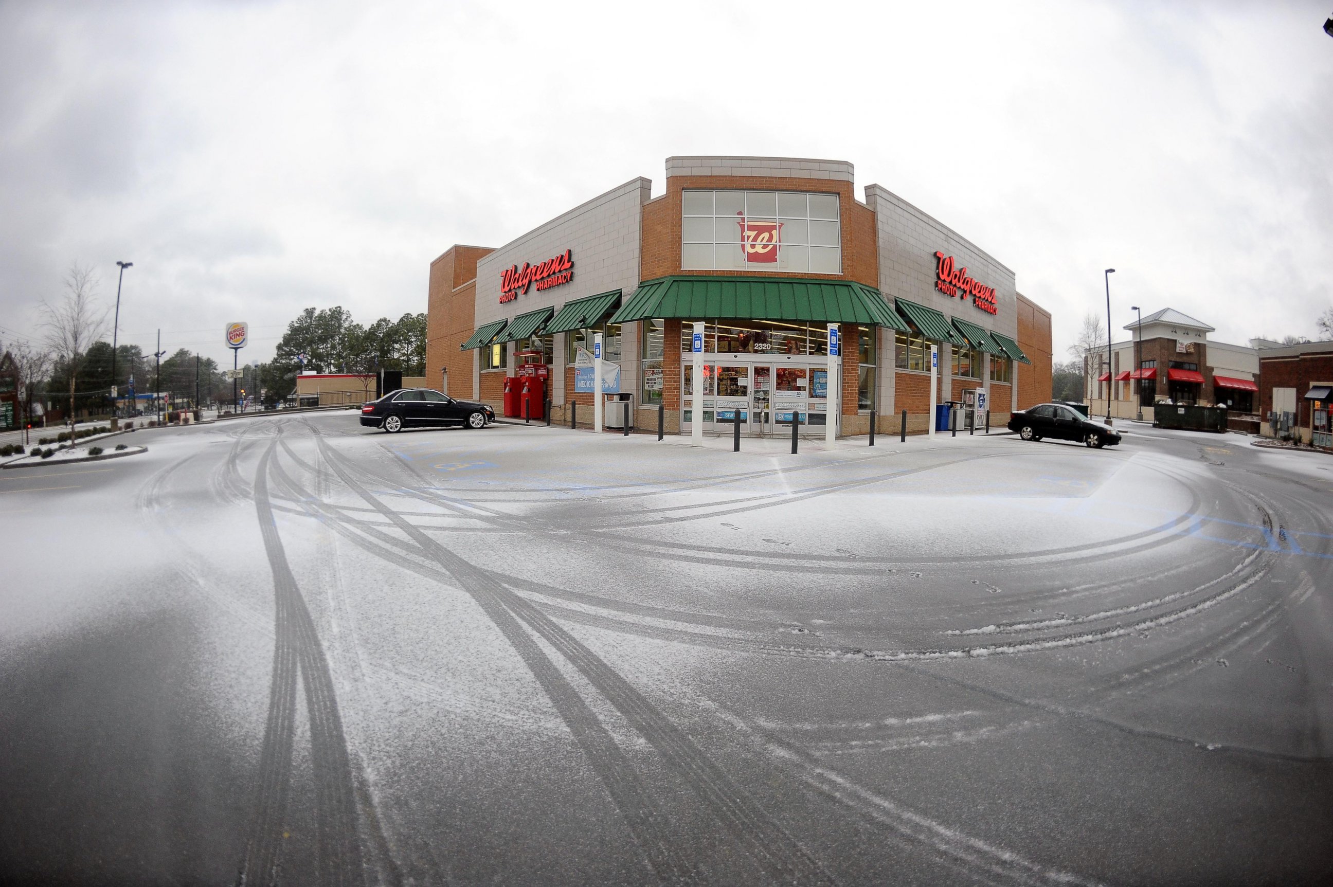 PHOTO: Snow covers the parking area of a a nearly vacant pharmacy, Feb. 12, 2014, in Atlanta. 