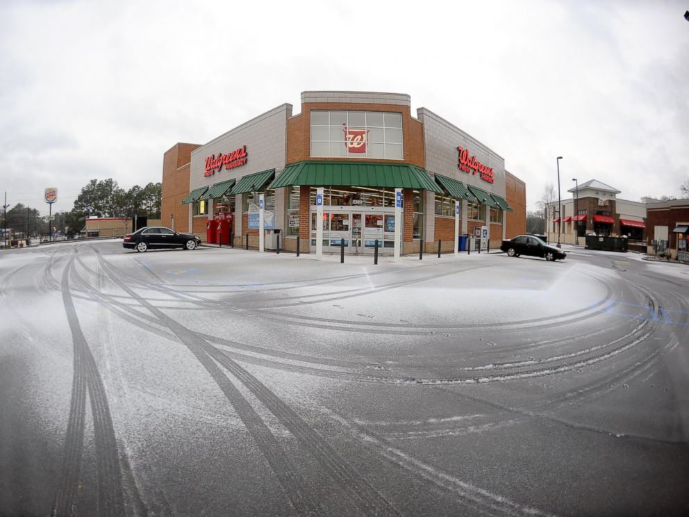 PHOTO: Snow covers the parking area of a a nearly vacant pharmacy, Feb. 12, 2014, in Atlanta.