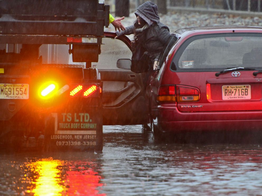 A woman is rescued from rising water after her Toyota Camry station wagon stalled out on West Fort Lee Rd as she approached the Hackensack River Tuesday morning, Dec. 9, 2014, in Bogota, N.J.
