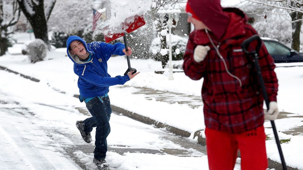 Austin Peters, left, 15, of Phillipsburg, N.J., uses a shovel to throw snow at Codi Consentino, right, 15, of Phillipsburg, as they walk up John Mitchell Avenue, Dec. 10, 2013. Much of Pennsylvania got socked Tuesday with another snowstorm that closed schools, delayed flights and made travel difficult through parts of the state. 