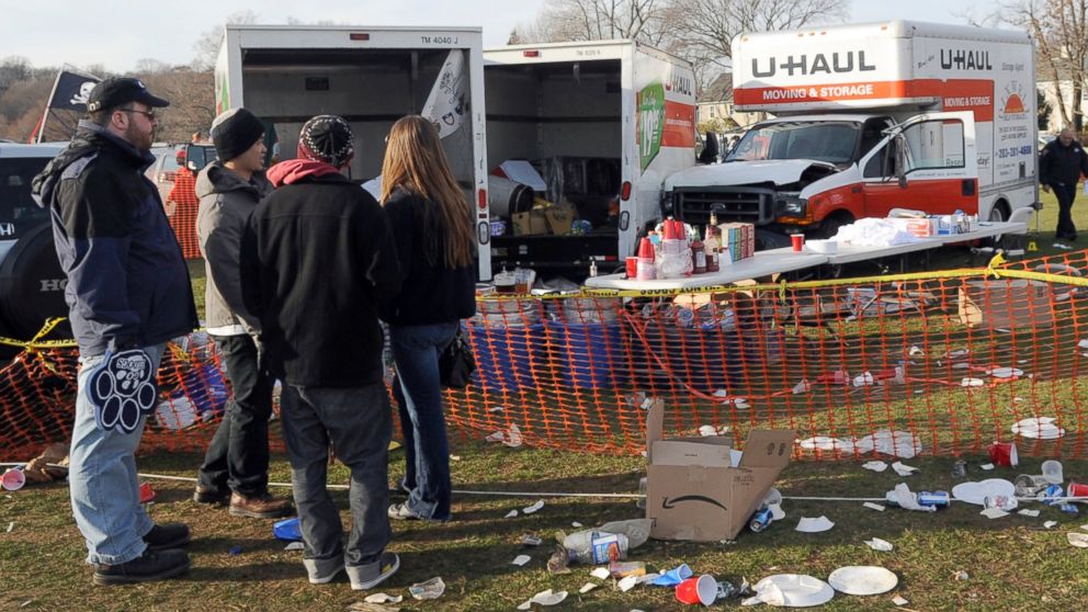 People look at the scene of a fatal accident in a parking area outside an NCAA college football game between Harvard and Yale, in New Haven, Conn., Nov. 19, 2011.