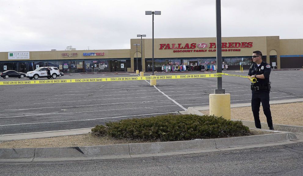 An APD Officer extends crime tape to block the entrance to the parking lot following  a fatal explosion behind Smith's Food and Drug in Albuquerque N.M., Feb. 4, 2019.