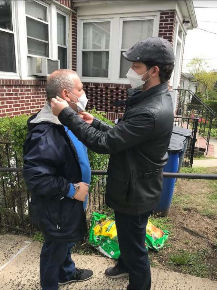 PHOTO: Alex DiMaio, executive director at Special Citizens Futures Unlimited, helps one of his residents to put on a facemask in the Bronx, New York City, on April 14, 2020.