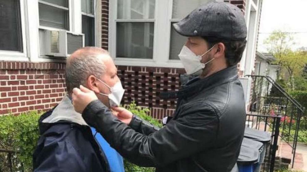 PHOTO: Alex DiMaio, executive director at Special Citizens Futures Unlimited, helps one of his residents to put on a facemask in the Bronx, New York City, on April 14, 2020.