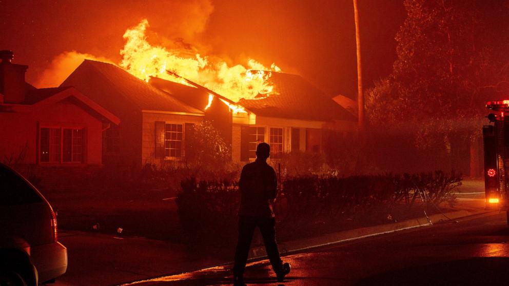 PHOTO: A firefighter walks toward a burning structure as the Eaton Fire advances on Jan. 7, 2025 in Altadena, California.