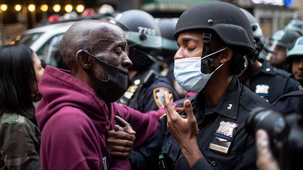 PHOTO: A protester and an officer shake hands in the middle of a standoff during a rally calling for justice over the death of George Floyd Tuesday, June 2, 2020, in New York. Floyd died after being restrained by Minneapolis police officers on May 25.