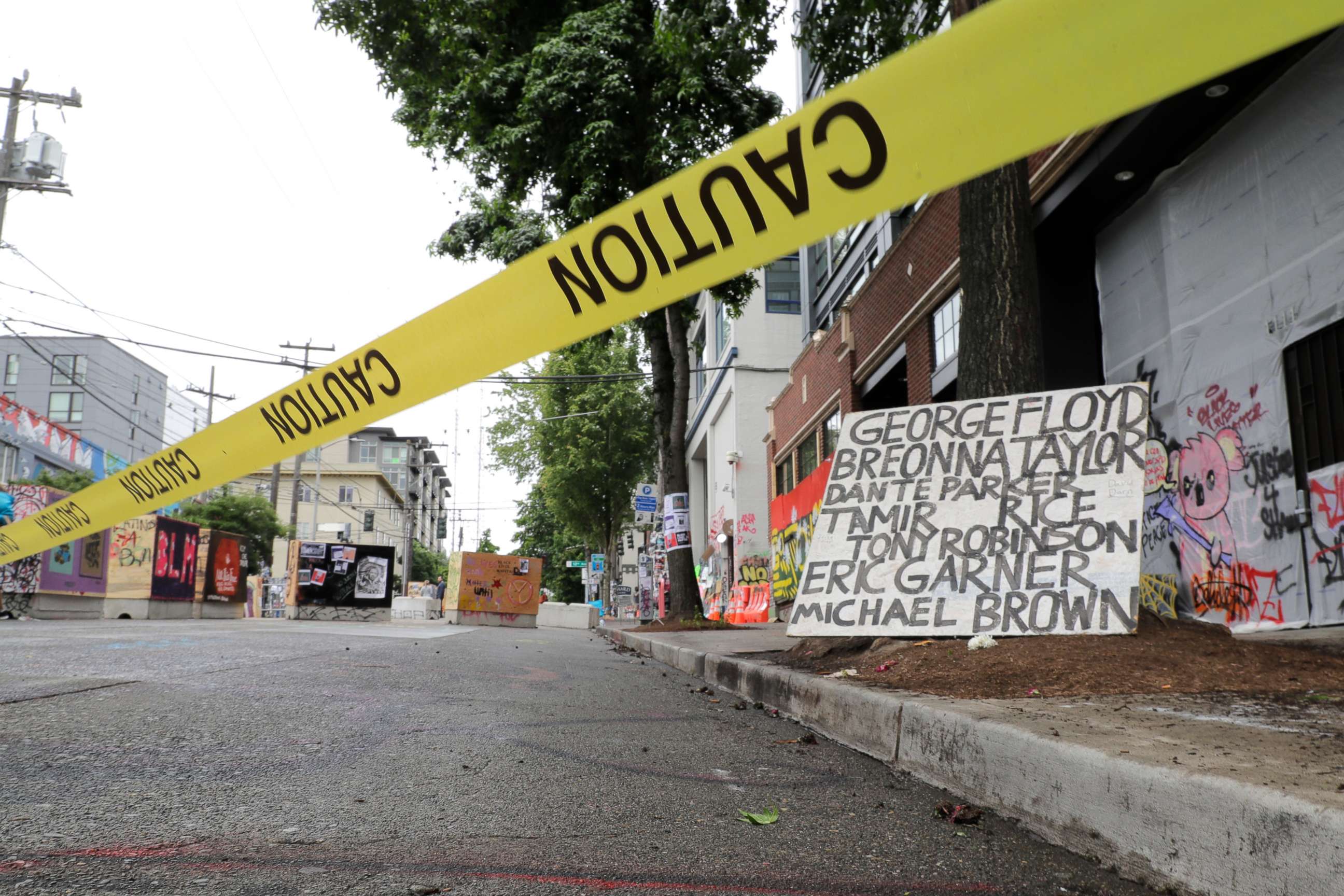 PHOTO: Caution tape is shown near a sign with the names of victims of police violence, Saturday, June 20, 2020, at the Capitol Hill Occupied Protest zone in Seattle. It is unknown who put the tape in place. 