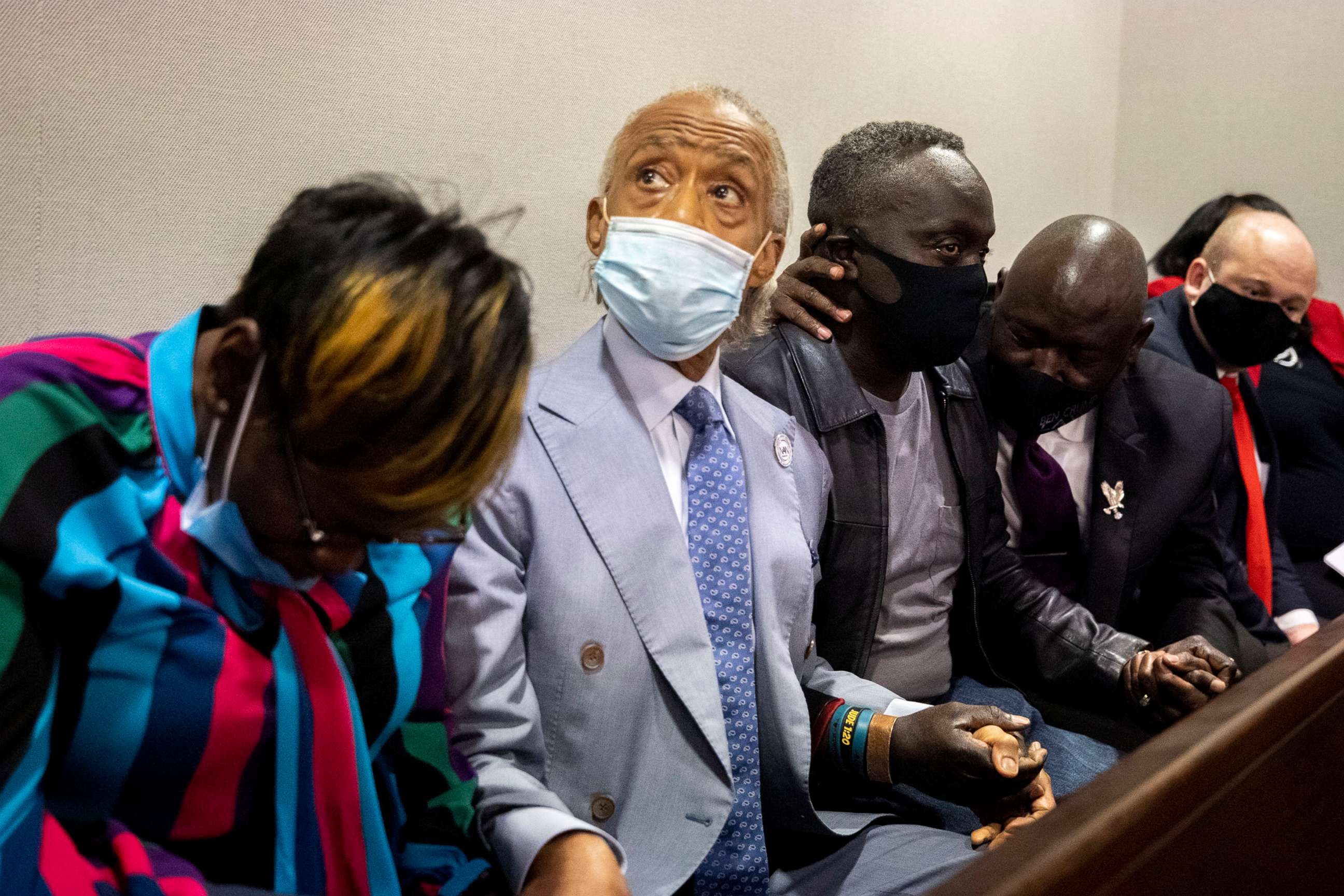 PHOTO: Ahmaud Arbery's father Marcus Arbery, center right, and Rev. Al Sharpton hold hands after the jury convicted Travis McMichael in the Glynn County Courthouse, Nov. 24, 2021, in Brunswick, Ga.