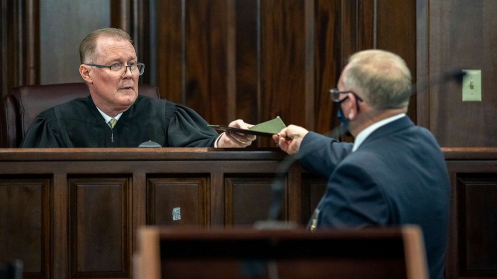 PHOTO: Superior Court Judge Timothy Walmsley is handed the jury's verdict from a bailiff during the trial of Greg McMichael and his son, Travis McMichael, and a neighbor, William "Roddie" Bryan, Nov. 24, 2021, in Brunswick, Ga.