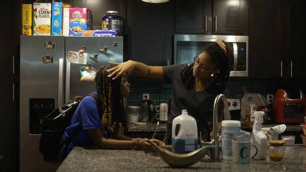 PHOTO: Jenny Burrows, 25, cares for her sisters, Zoe and Sierra Clarke. Jenny and her brother, Tre, are now in charge after their mother, Cindy Dawkins, died of Covid.