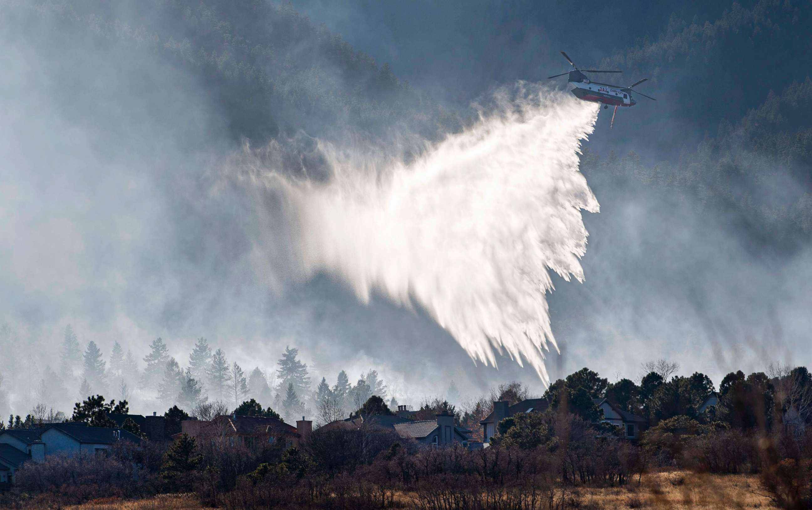 PHOTO: A Chinook helicopter drops water on a wildfire near Bear Creek Regional Park on the westside of Colorado Springs, Colo., Thursday, Nov. 19, 2020.