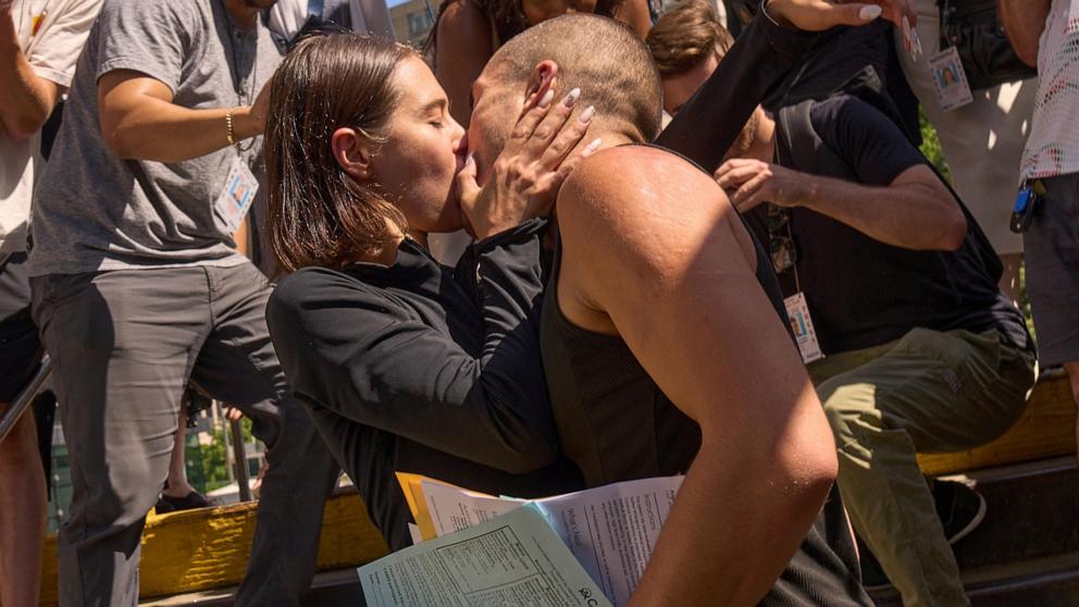 PHOTO: Angela Nikolau and Vanya "Ivan" Beerkus, the couple who climbed to the top of the Empire State Building spire, kiss at the Brooklyn Bridge-City Hall train station after departing New York City Criminal Court after their arraignment, July 2, 2026.