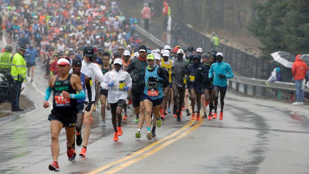 PHOTO: Qixiang Zhou, left, of China, leads a pack of runners during the 122nd Boston Marathon, April 16, 2018, in Boston.