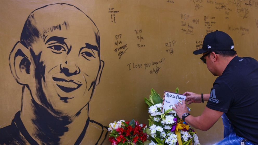 PHOTO: A fan places flowers to mourn former Los Angeles Lakers basketball player Kobe Bryant following his death overnight in the US, near the "House of Kobe" gym built in honour of his 2016 visit to the Philippines, in Manila on January 27, 2020. 