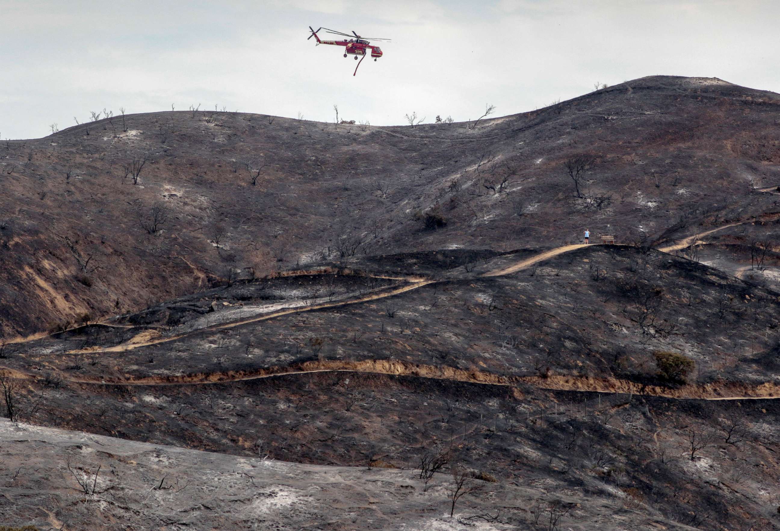 PHOTO: A firefighting helicopter flies over a charred hillside during the La Tuna Canyon fire near Burbank, California, September 3, 2017