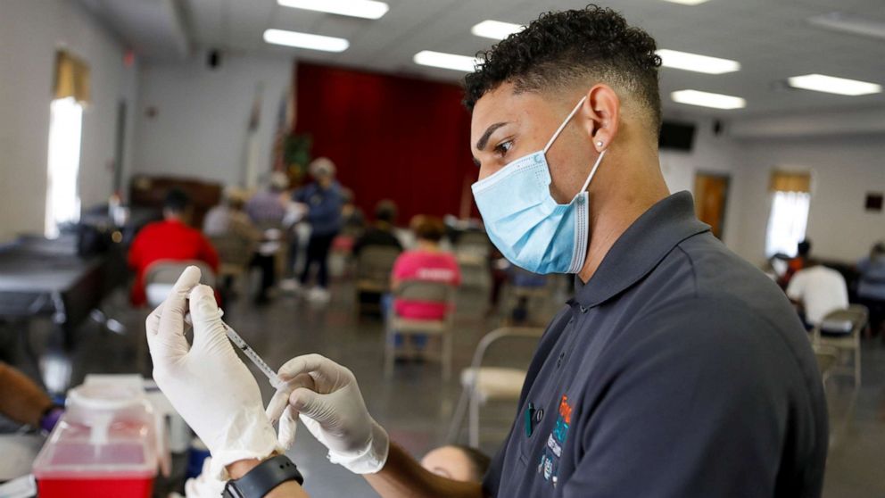 PHOTO: A man prepares a dose of a vaccine as vaccinations against the coronavirus disease (COVID-19) are held at the historic Greater Bethel Missionary Baptist Church in Tampa, Florida, U.S. February 14, 2021. 