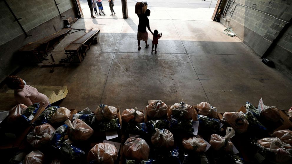 PHOTO: A resident picks up free groceries distributed by the Chelsea Collaborative's food pantry, in Chelsea, a city hard hit by the coronavirus disease (COVID-19) outbreak, Massachusetts, U.S., September 15, 2020. 