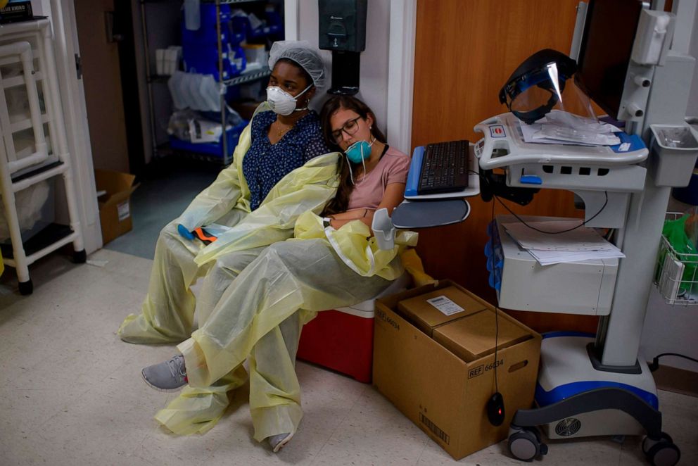 PHOTO: A healthcare worker closes her eyes and leans on her colleague to rest outside of the Covid-19 Unit at United Memorial Medical Center in Houston, Texas on July 2, 2020.