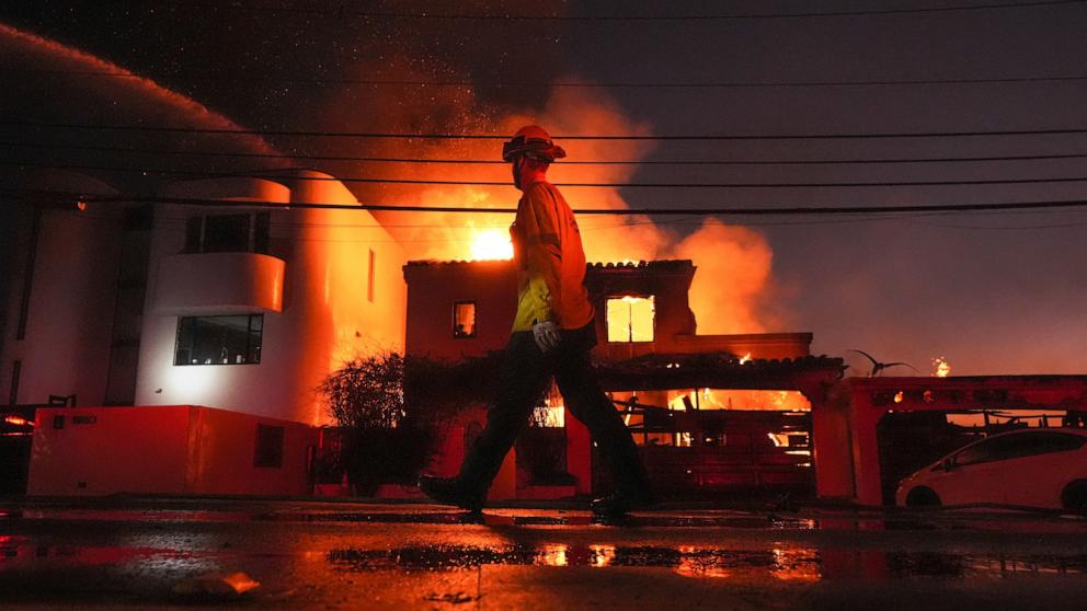 PHOTO: A firefighter walks past a burning structure as the Palisades Fire continues to burn in the Pacific Palisades neighborhood of Los Angeles, on Jan. 8, 2025.