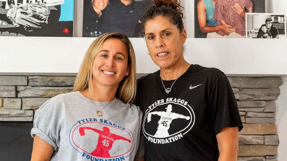 PHOTO: Carli Skaggs, wife of Tyler Skaggs and his mother Debbie Skaggs stand in front of photos of former Los Angeles Angels pitcher Tyler Skaggs, June 28, 2020, in Los Angeles. 