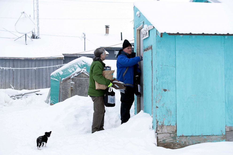 PHOTO: Census Bureau director Steven Dillingham, right, knocks on the door alongside census worker Tim Metzger as they arrive to conduct the first enumeration of the 2020 Census in Toksook Bay, Alaska, Jan. 21, 2020. 