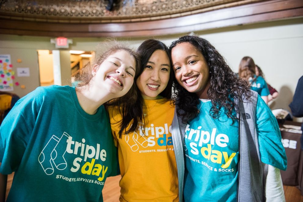 PHOTO: Charlotte Kim, center, poses with fellow volunteers at the sock donation event she organized.