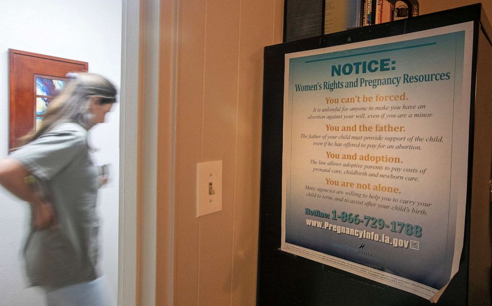 PHOTO: An abortion clinic staffer passes a women's rights poster at Hope Medical Group for Women in Shreveport, La., July 6, 2022. 