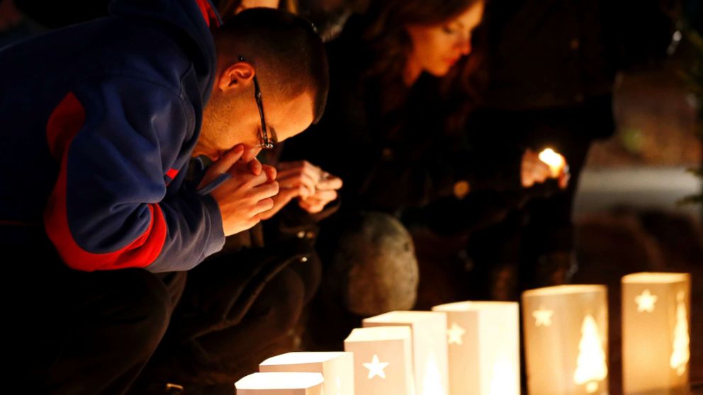 PHOTO: A man reacts placing candles on a makeshift memorial in honor of the victims who died a day earlier when a gunman opened fire in an elementary school, Dec. 15, 2012, in Newtown, Conn.