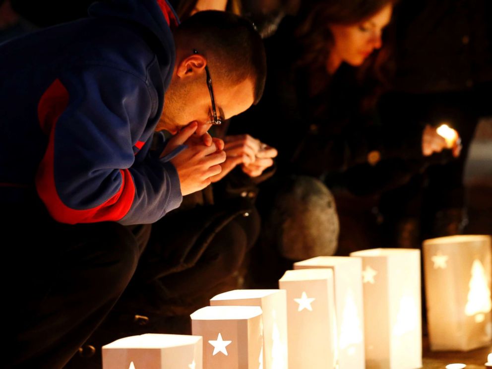 PHOTO: A man reacts placing candles on a makeshift memorial in honor of the victims who died a day earlier when a gunman opened fire in an elementary school, Dec. 15, 2012, in Newtown, Conn.