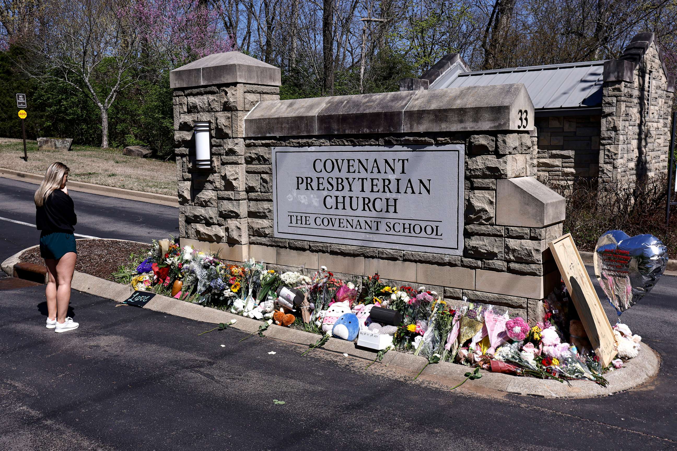 PHOTO: A woman pauses as she visits a memorial at the entrance to The Covenant School, March 29, 2023, in Nashville, Tenn.