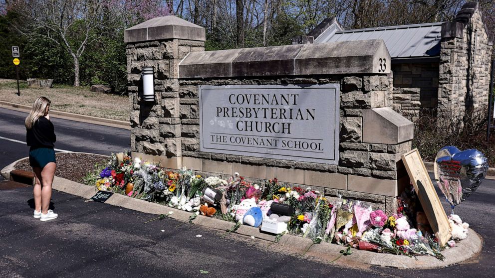 PHOTO: A woman pauses as she visits a memorial at the entrance to The Covenant School, March 29, 2023, in Nashville, Tenn.