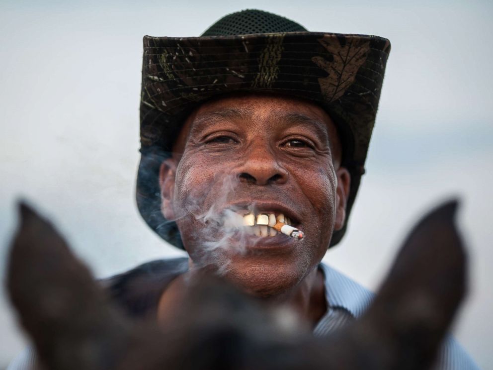 PHOTO: A cowboy named James shows off his golden grill while smoking a cigarette in Bolivar County, Miss.