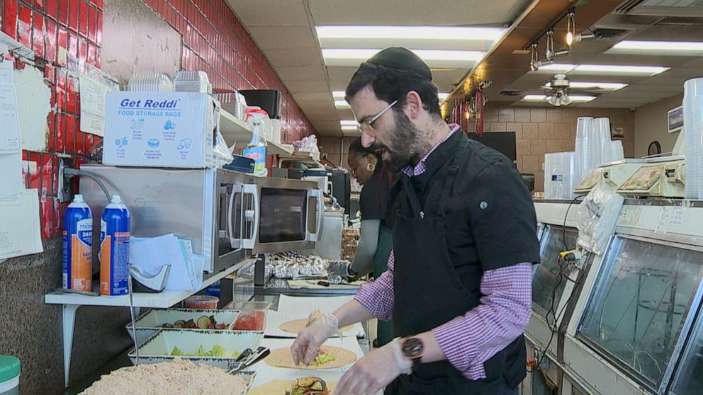 PHOTO: Knish Shop owner Mosie Treuhaft is seen making tuna sandwich wraps that will later be donated to medical staff working in Sinai's emergency room in Baltimore, Maryland.