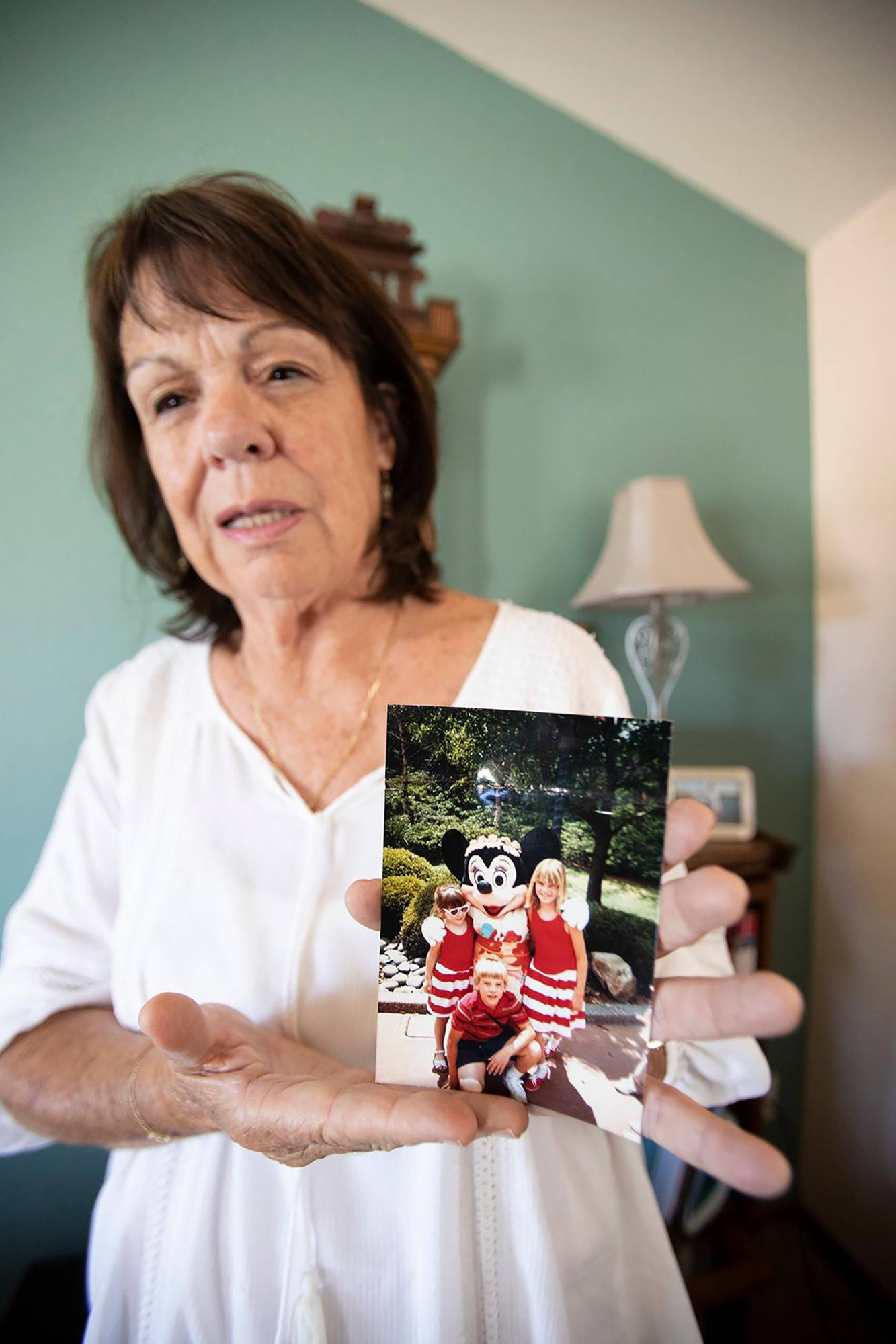 PHOTO: Denise Smart holds a favorite photo of her children, Kristin, Lindsey and Matt, May 24, 2023, at her home in Stockton, California.