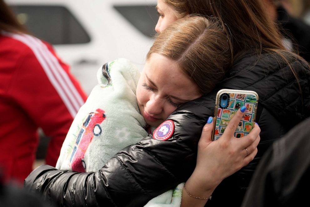 PHOTO: Two women hug when reunited following a shooting at East High School, March 22, 2023, in Denver.