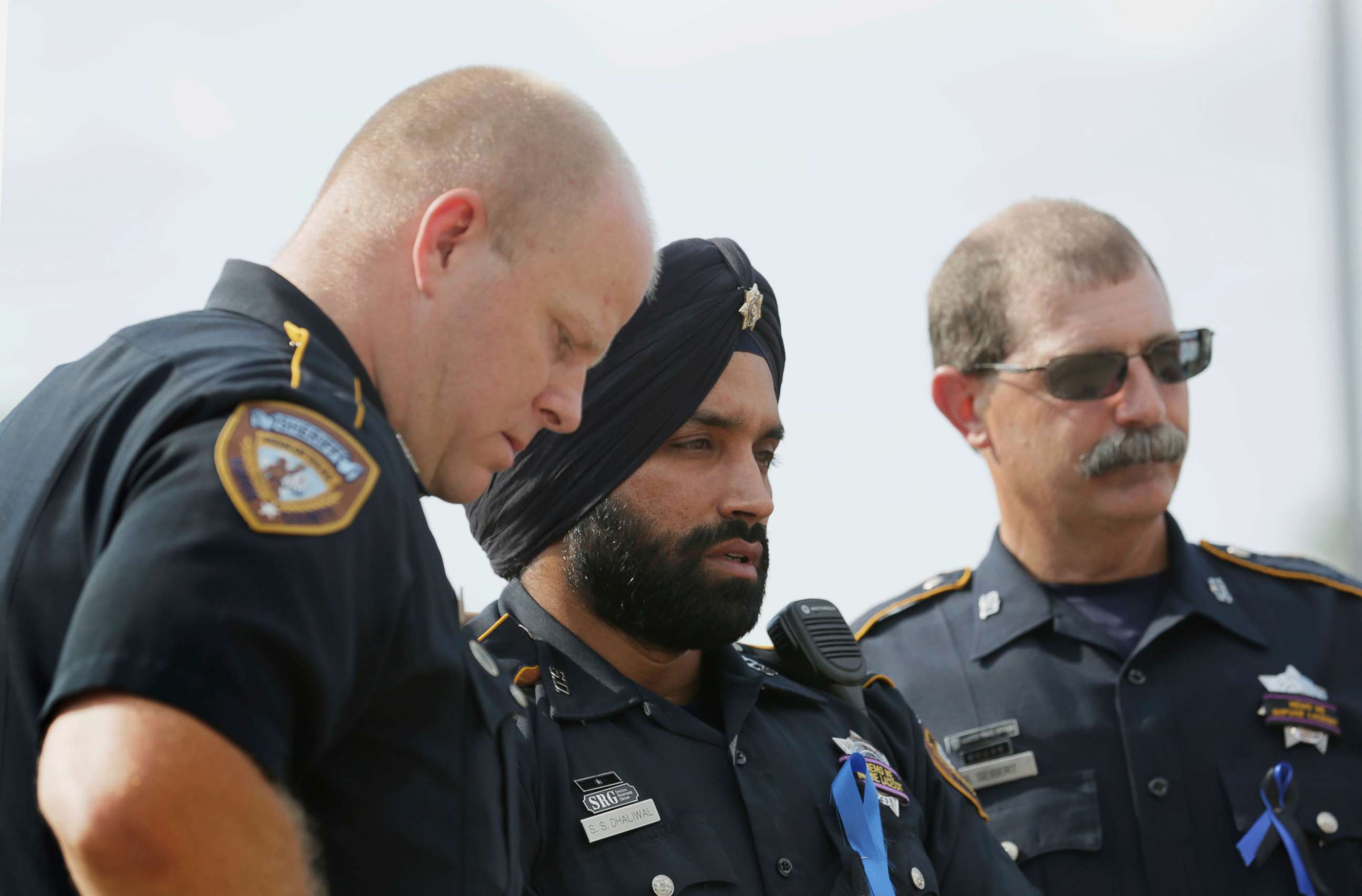 PHOTO: In this Aug. 30, 2015, photo, Harris County Sheriff's Deputy Sandeep Dhaliwal, center, grieves with Deputies Dixon, left, and Seibert, right, at a memorial for Deputy Darren Goforth, at the Chevron where he was killed, in Houston.