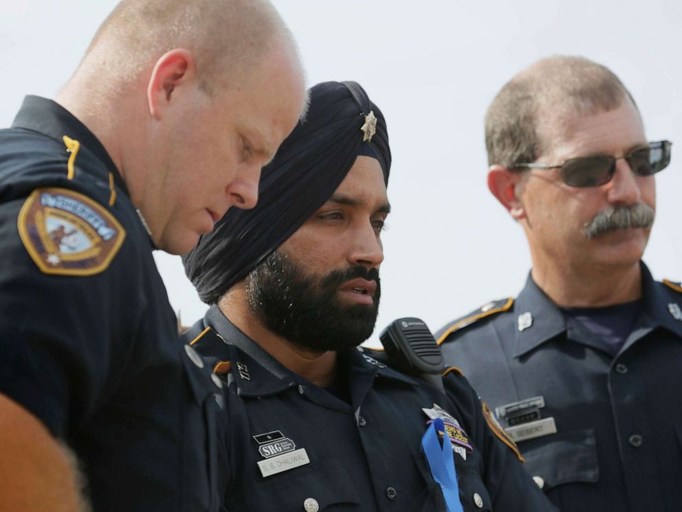 PHOTO: In this Aug. 30, 2015, photo, Harris County Sheriffs Deputy Sandeep Dhaliwal, center, grieves with Deputies Dixon, left, and Seibert, right, at a memorial for Deputy Darren Goforth, at the Chevron where he was killed, in Houston.