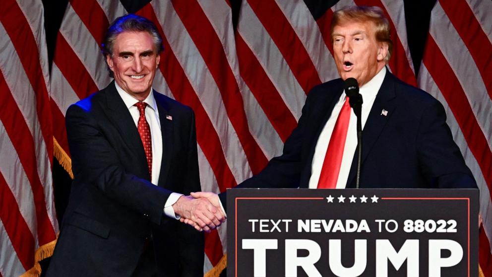 PHOTO: Republican Governor of North Dakota Doug Burgum shakes hands with former President and 2024 presidential hopeful Donald Trump during a Caucus Night watch party in Las Vegas, Nevada, Feb. 8, 2024. 