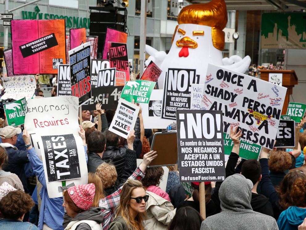 PHOTO: Protesters hold up signs during a Tax Day Protest March outside Bryant Park in New York, April 15, 2017. The protest will march up to Trump Tower on 5th Avenue. 