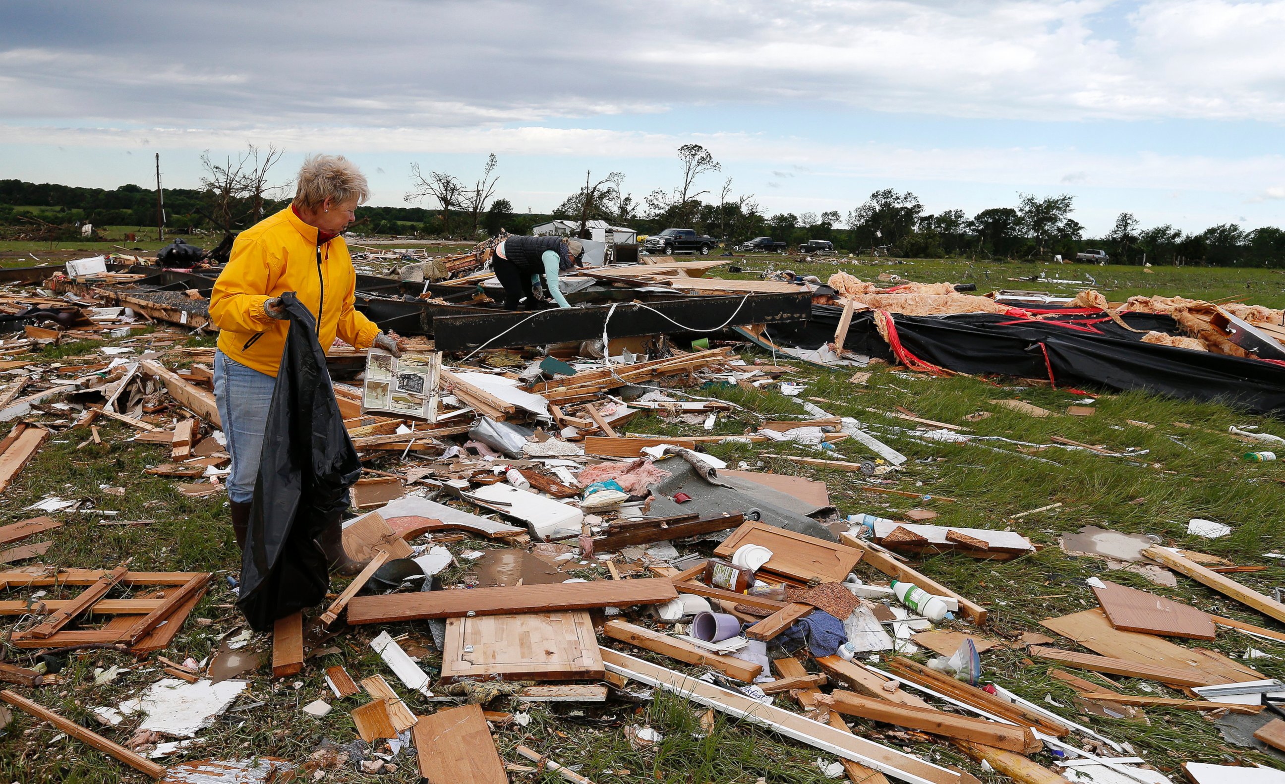 PHOTO: Two women retrieve items for their neighbor from the remains of their trailer home that was destroyed when a large tornado hit the area near Canton, Texas, April 30, 2017. 