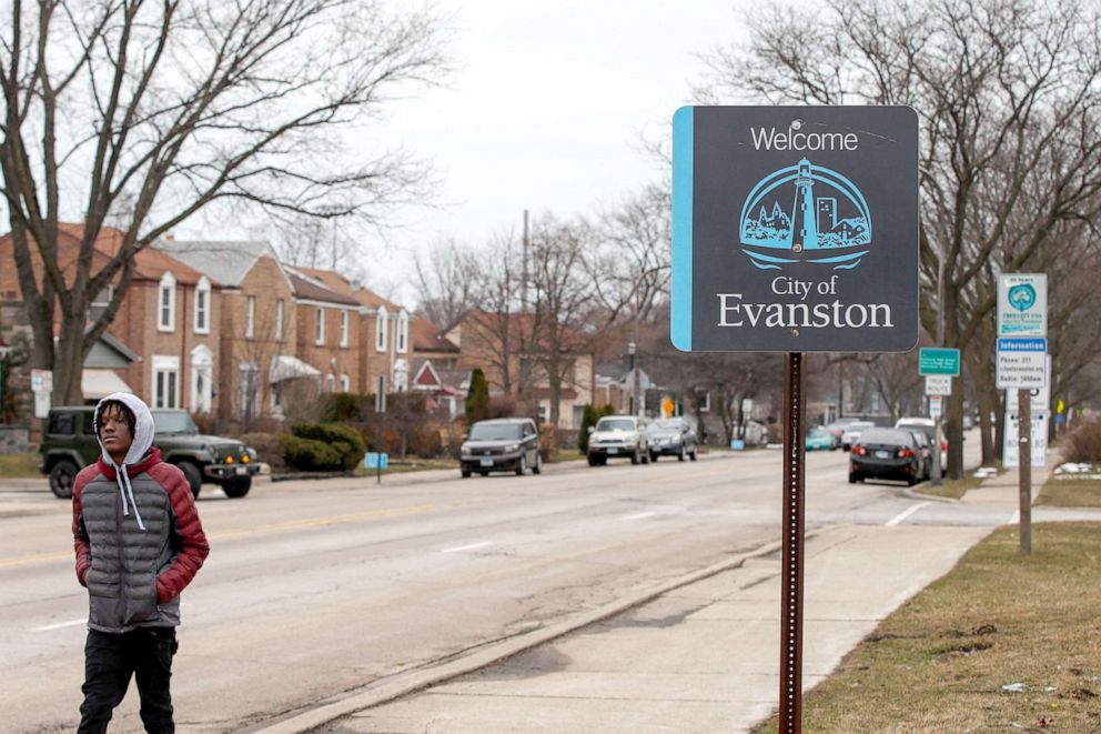 PHOTO: A man walks by a sign welcoming people to Evanston, Illinois, on March 16, 2021. The Chicago suburb is set to become the first place in the United States to provide reparations to its Black residents, planning to distribute $10 million. 