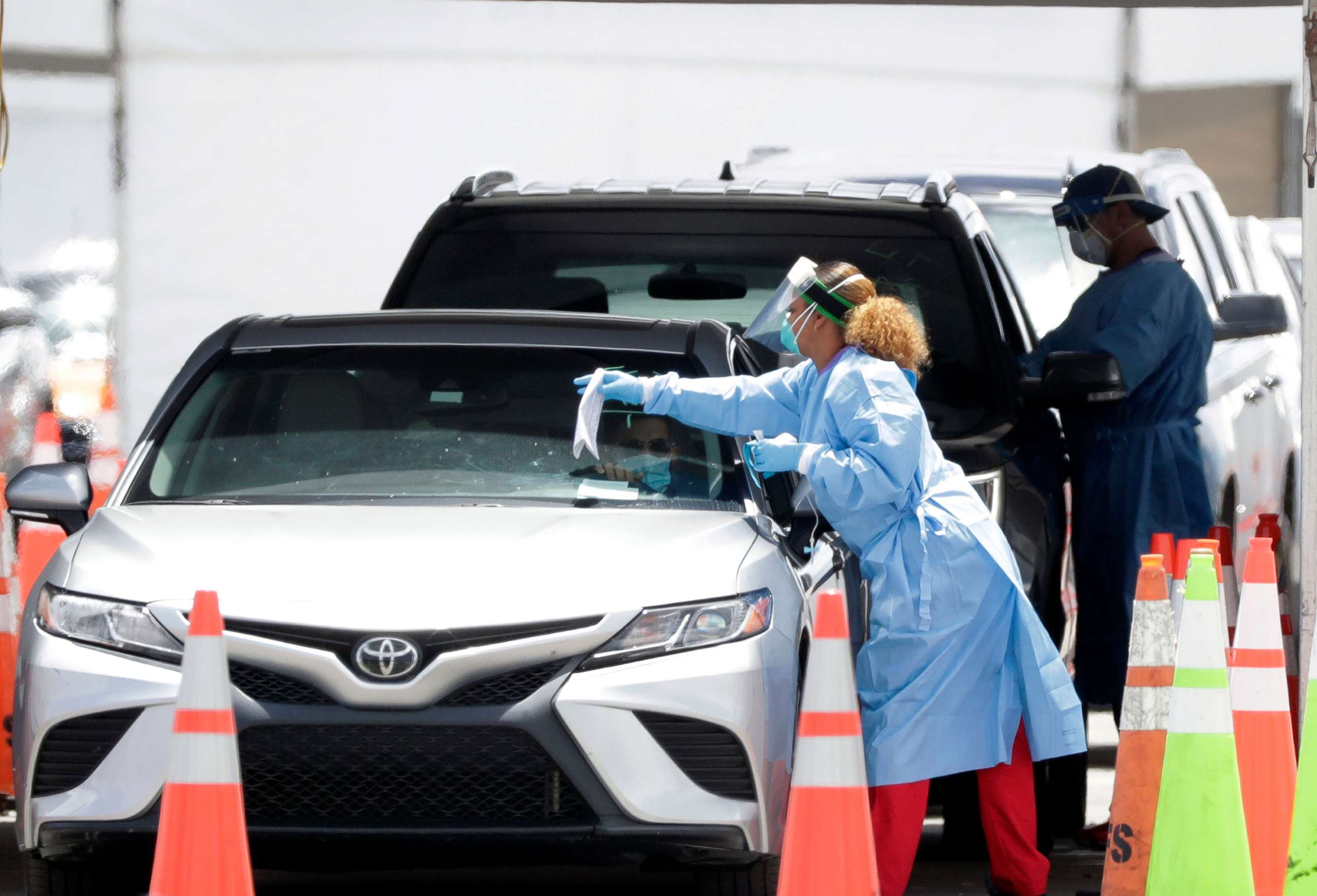 PHOTO: Healthcare workers prepare to test drivers at a drive-through coronavirus testing site outside of Hard Rock Stadium, June 26, 2020, in Miami Gardens, Fla. 