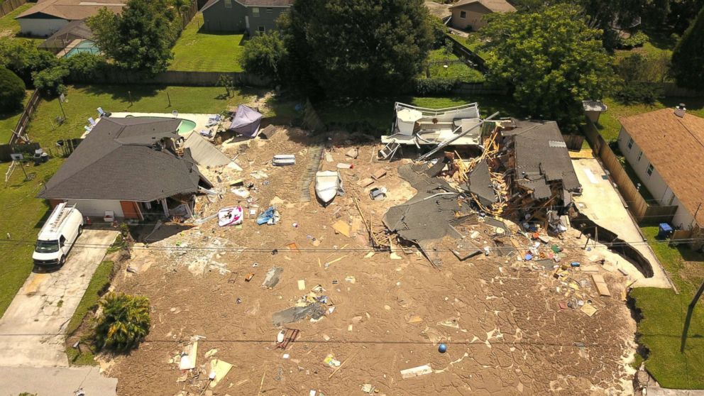 PHOTO: In this aerial photo, debris is strewn about after a sinkhole damaged two homes in Land O' Lakes, Fla., July 14, 2017.