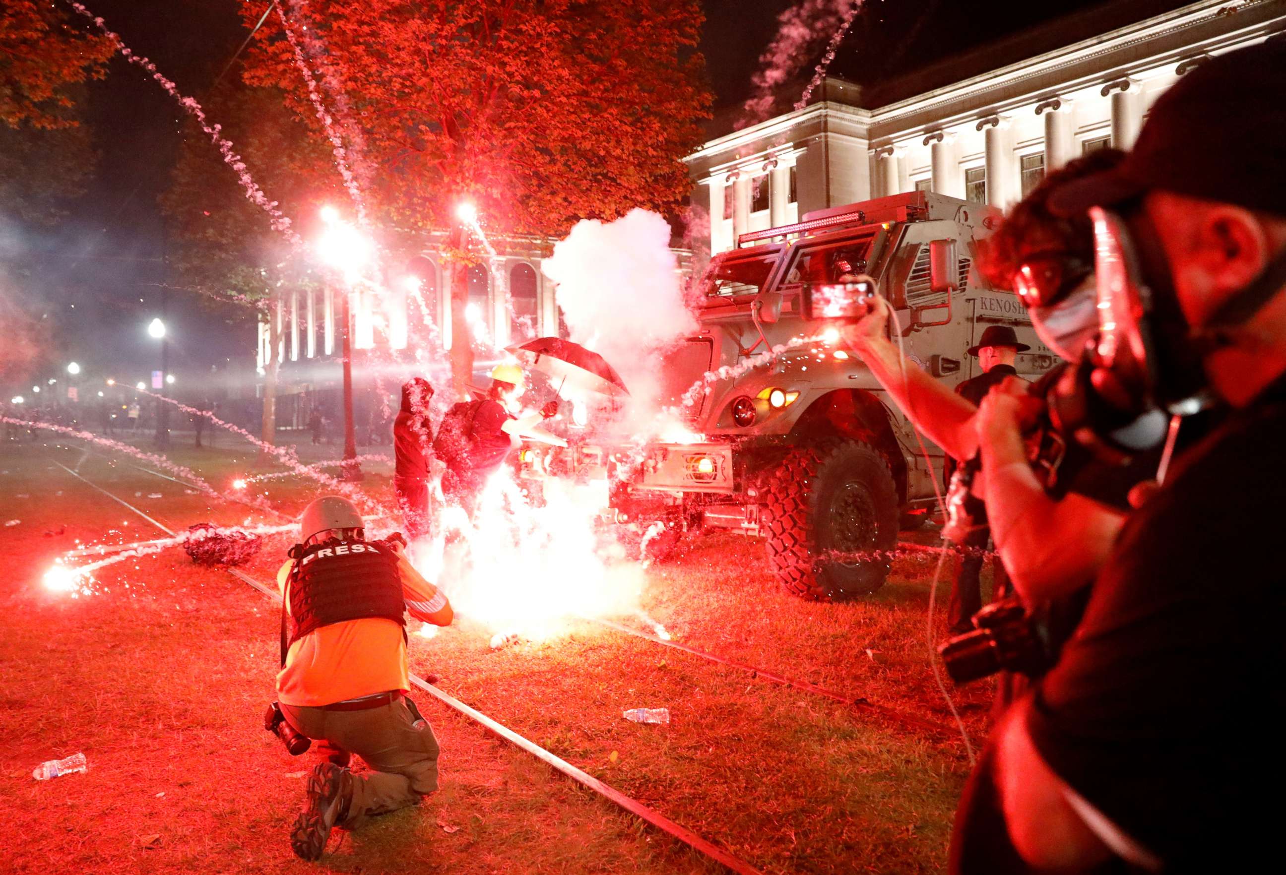 PHOTO: Flares go off in front of a Kenosha Country Sheriff Vehicle as demonstrators take part in a protest following the police shooting of Jacob Blake, a Black man, in Kenosha, Wisconsin, U.S. August 25, 2020. REUTERS/Brendan McDermid    